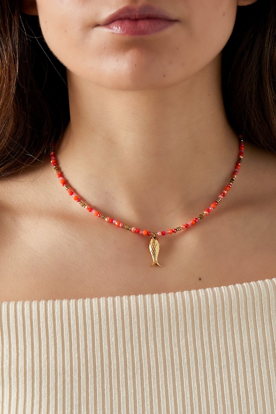 Model wearing gold-plated fish charm necklace with orange beads – Uzuri